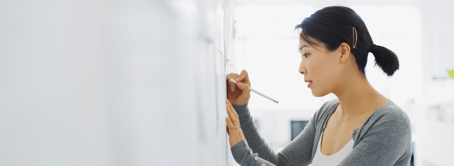 Young woman writing on a white board